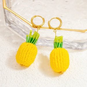 Détail des boucles d'oreilles faites main en perles ananas jaunes avec fermoirs dorés