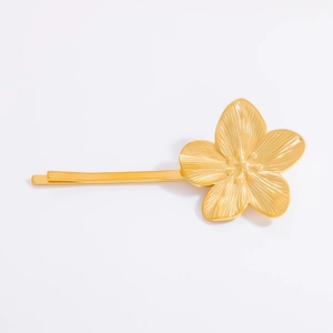 Detail of 18K gold stainless steel flower hair clip with brushed texture on white background
