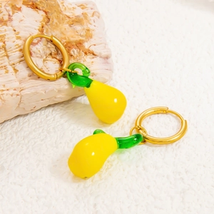 Vue macro de boucles d'oreilles créoles dorées 18K avec pendentifs fruits en verre