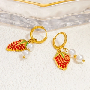 Détail des boucles d'oreilles fraise en or 18 carats avec émail rouge et perles