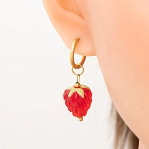 Détail d'une boucle d'oreille en or 18K avec pendentif fraise en verre rouge réaliste