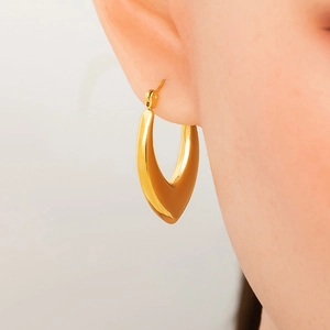 Close-up of heart-shaped 18K gold plated stainless steel hoop earrings on ear