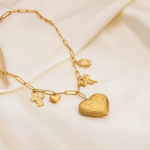 Close-up of gold paperclip chain necklace featuring heart locket and mixed charm pendants