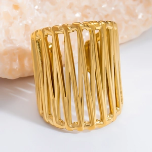Detail of a wide hollow cage gold ring with intricate interwoven lines on a mineral stone