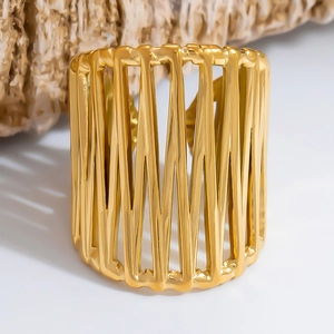 Macro shot of gold hollow geometric cuff bracelet with vertical bars and metallic shine