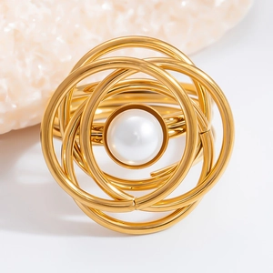 Macro shot of gold layered ring design with a white pearl and refined artistic metal texture