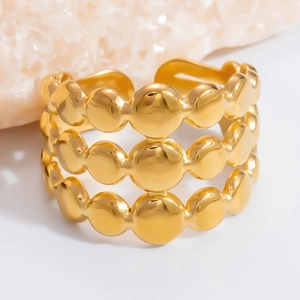 Macro shot of gold stainless steel three-layer beaded open ring with polished finish