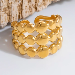 Macro detail of three-layer wavy gold beaded ring with polished mirror finish surface