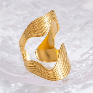 Detailed view of the wavy textured golden cuff bracelet with high gloss polished finish
