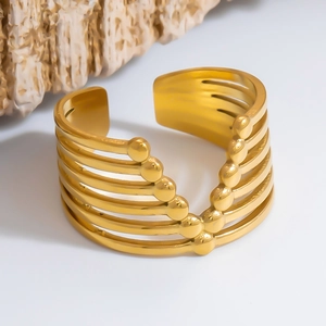 Detail view of a layered gold stainless steel cuff bracelet with bead accents