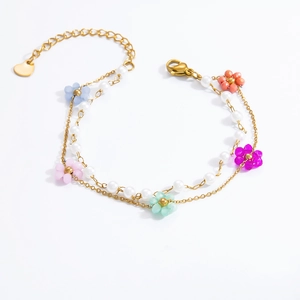 Detail of double-layer gold chain bracelet with colorful flower beads and pearls