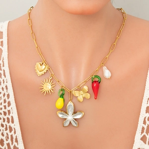 Close-up of golden paperclip chain necklace with lemon, heart, and pearl charms