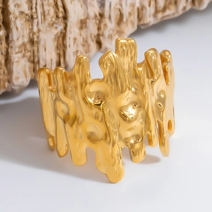 Detailed macro shot of a wide gold-plated ring with organic irregular lava textures
