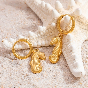 Dettaglio macro di orecchini a cerchio a forma di cavalluccio marino placcati oro 18k