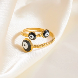 Détail macro d'une bague torsadée plaquée or avec trois breloques œil grec en émail