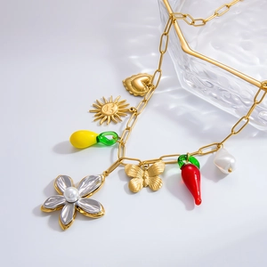Detailed view of a gold paperclip chain necklace with charms like pearl flower and butterfly