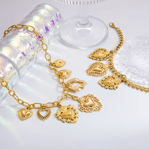 Close-up of gold chain bracelets with embossed heart and sunburst pendants on glass stands