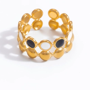 Détail du bracelet doré à double rangée avec motifs circulaires en émail noir et blanc