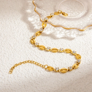 Close-up of gold chain bracelet with oval links and sparkling clear zircon stones