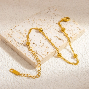 Detailed view of 18k gold plated stainless steel chain with lobster clasp and round beads