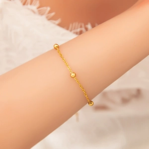 Close-up of 18k gold plated stainless steel twisted chain bracelet with solid beads on wrist