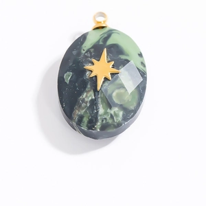 Macro view of oval dark green marble resin pendant with golden North Star inlay detail