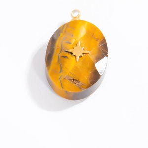 Detailed macro view of an oval tiger eye stone pendant with a golden star inlay and bail