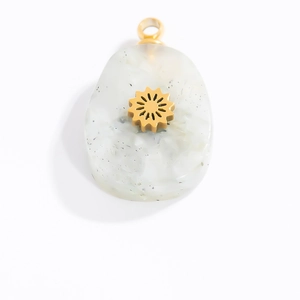 Detail of drop shaped resin charm with golden sun inlay and sparkling silver flakes