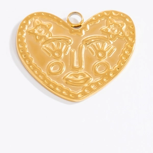 Detail eines 18K Gold Herzanhängers mit geprägtem Gesicht und kleinen Sternakzenten