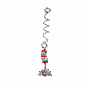 Macro detail of silver spiral hair coil with colorful beads and lotus flower pendant