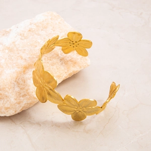 Detail of 18K gold plated floral open cuff bracelet with brushed matte petals texture