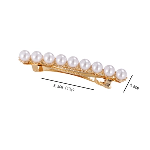 Macro shot of a minimalist gold hair clip with ten white pearls, 8.5CM length detail