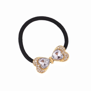 Close-up of heart-shaped crystal rhinestones on a gold bow tie hair accessory