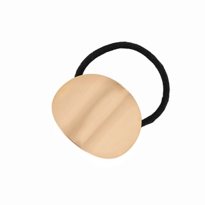 Minimalist elastic hair tie with a large oval brushed gold metal plate on white background