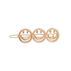 Detaillierte Makroansicht von drei goldenen Smileys auf einer polierten Haarspange