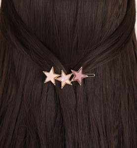Détail d'une pince à cheveux étoiles roses dégradées avec bordure dorée