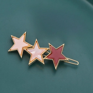Détail de la pince à cheveux avec trois étoiles en résine rose et bordeaux chic
