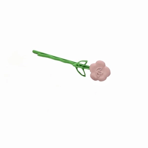 Dettaglio di un piccolo fermaglio a fiori rosa con perno verde e finitura opaca chic