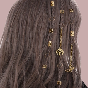 Détail de bagues de dreadlocks dorées avec pendentifs arbre de vie et papillon