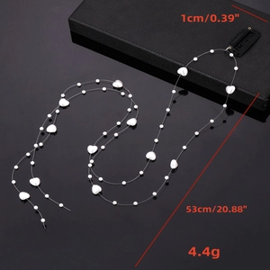 Détail de la chaîne de cheveux en perles de cœur avec fil transparent et clip BB noir