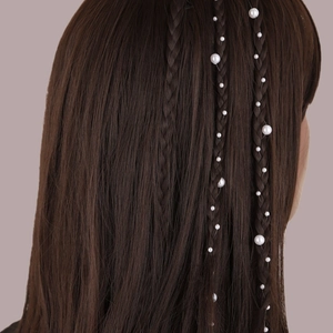 Détail de perles blanches artificielles sur fil invisible tressées en cheveux bruns