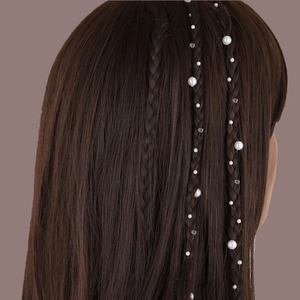 Détail de la chaîne de cheveux en perles et cristaux tressée dans une natte brune