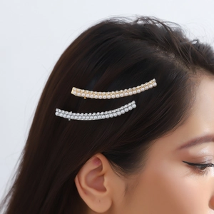 Elegant curved hair clip with faux pearls and rhinestones on a female model