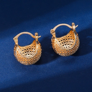 Détails macro de boucles d'oreilles panier ajouré dorées avec texture tissée et fermoir stable