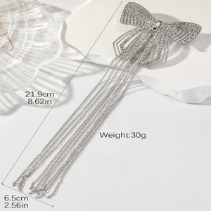 Vue détaillée du clip cheveux nœud argenté avec pompons en cristal, longueur 21,9cm et largeur 6,5cm