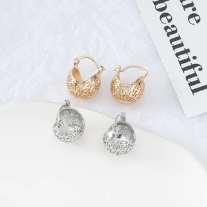Detailed close-up of hollow geometric earrings in gold and silver metallic finishes