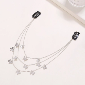 Detail of a three-layer silver tassel hair chain with eleven small metal butterflies and BB clips