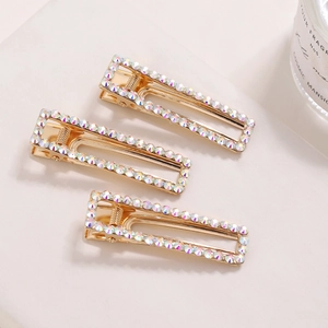 Close-up of three rectangle gold hair clips with AB crystal rhinestones in a row