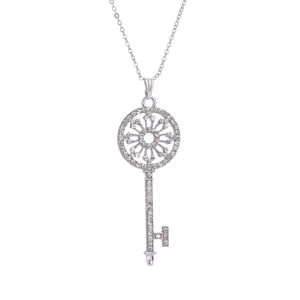 Close-up of a silver key pendant necklace featuring sparkling pavé crystals