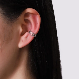 Minimalist silver heart ear cuff with multiple hollow heart links on ear cartilage